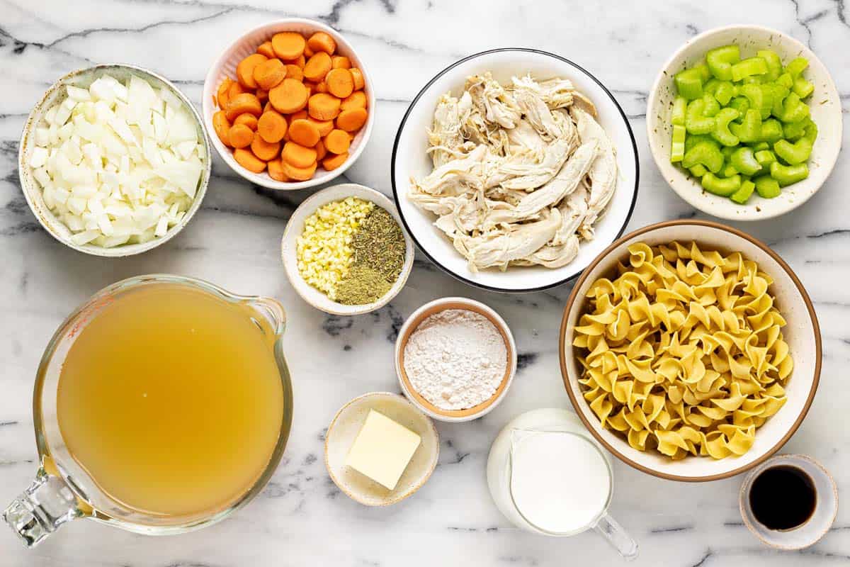 Bowls of ingredients to make rotisserie chicken noodle soup. 