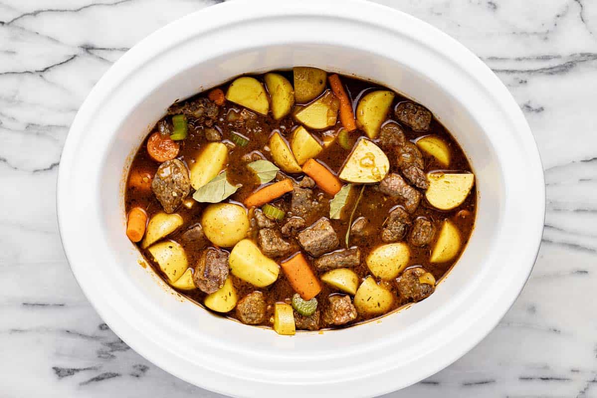 Ingredients to make slow cooker beef stew in a large crock pot. 