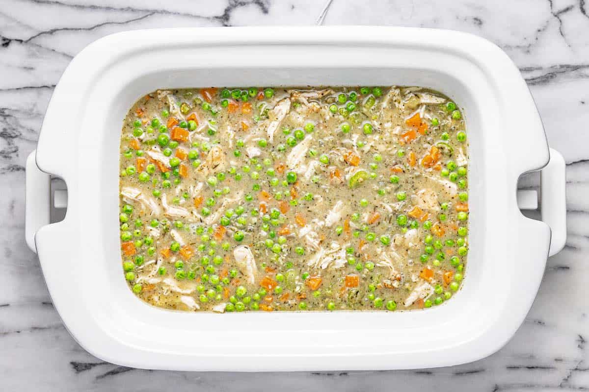 Slow cooker filled with creamy veggies and shredded chicken. 