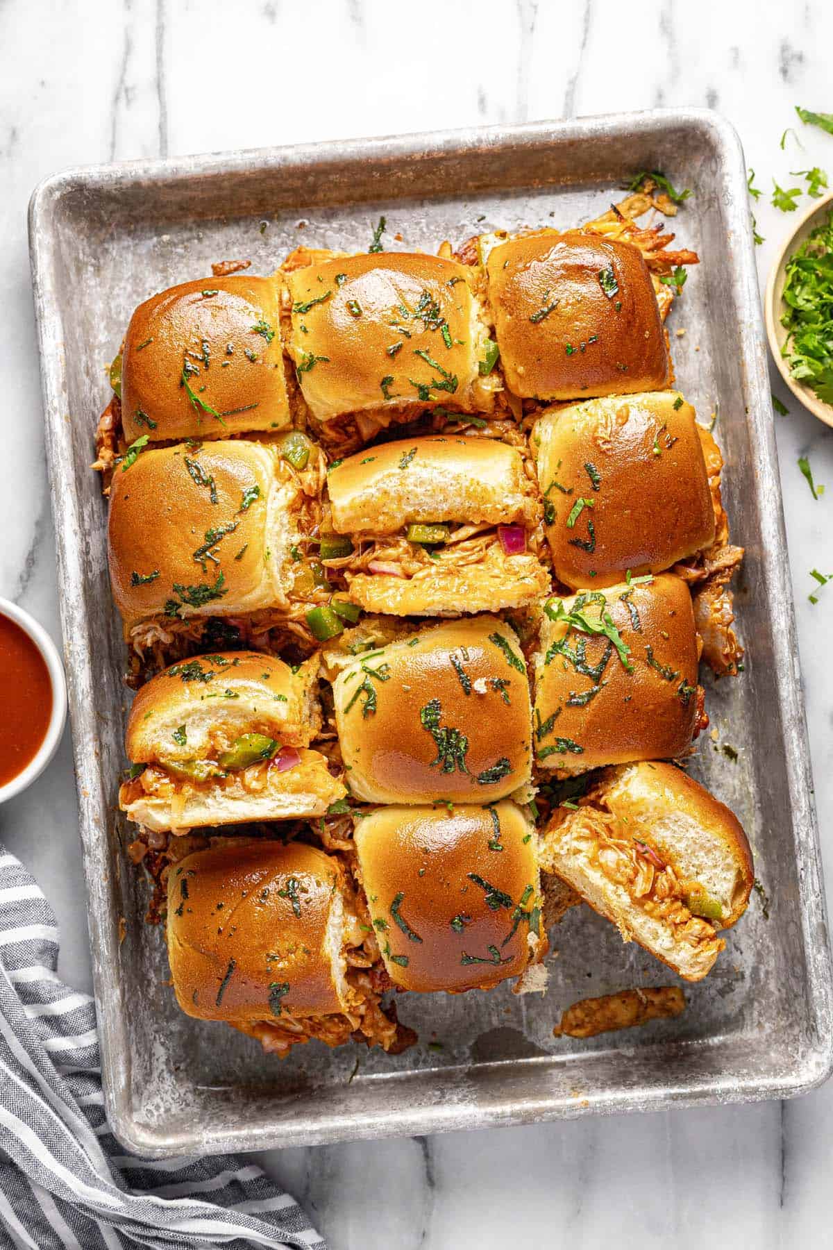 Baking sheet with chicken sliders on it. 