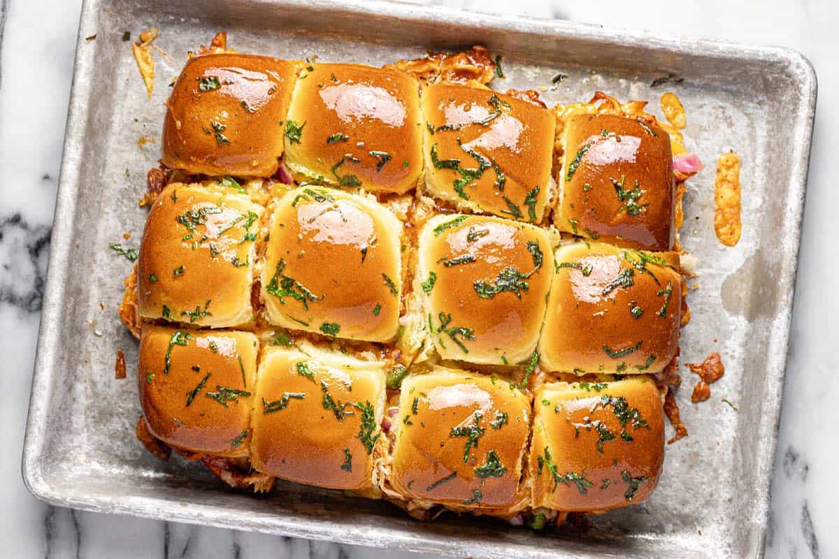 Homemade chicken BBQ sliders on a baking sheet. 