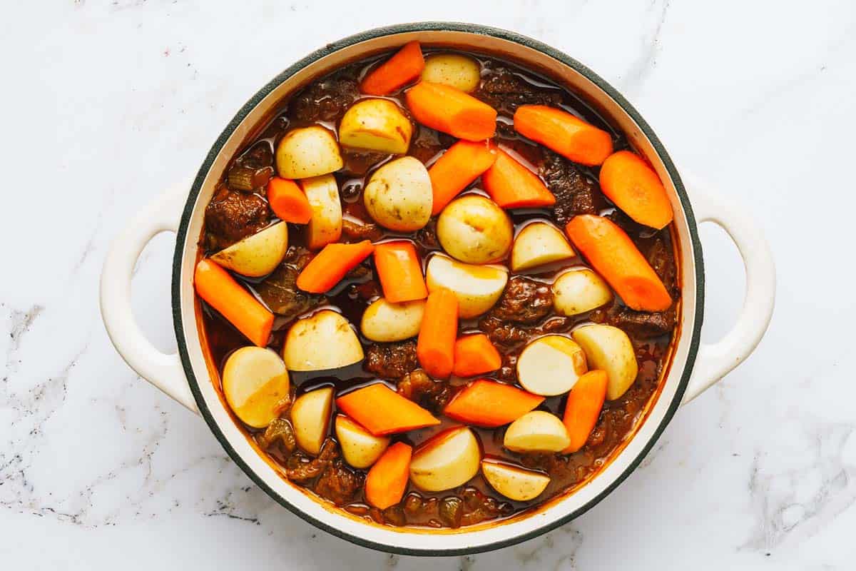 Large pot with ingredients to make Dutch oven beef stew. 