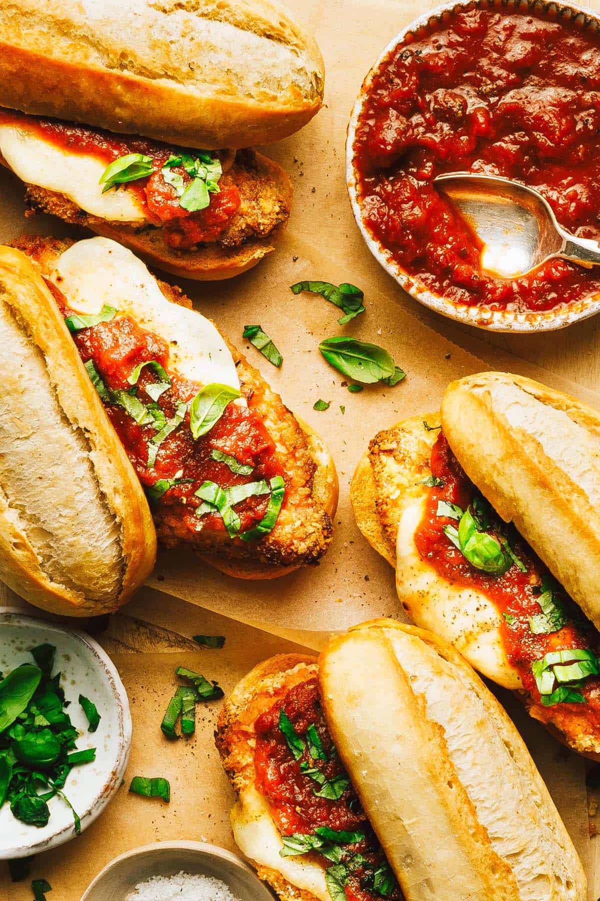 Homemade chicken Parmesan sandwiches and a bowl of marinara sauce. 