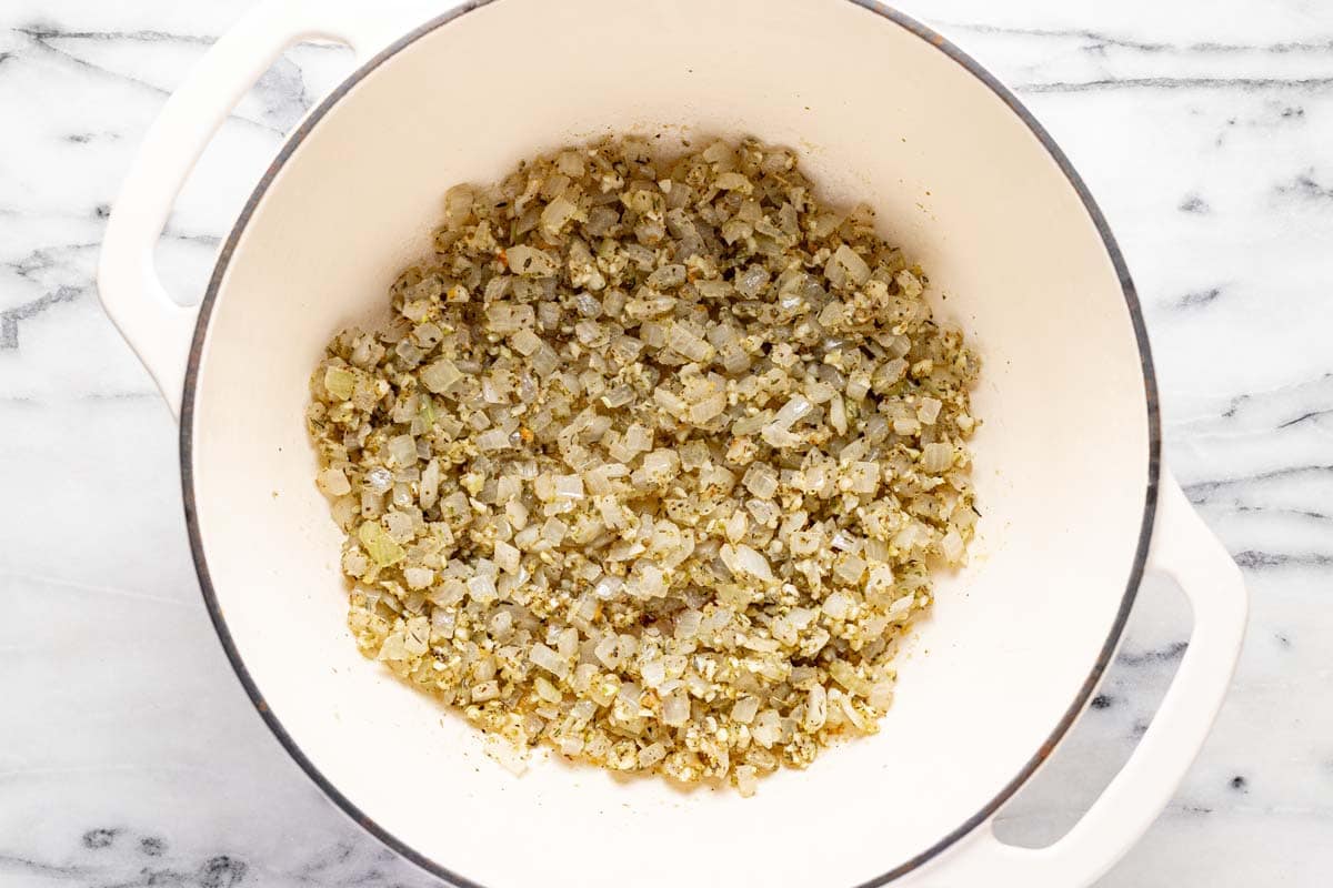 Large pot filled with sauteed veggies, garlic, herbs, and spices. 