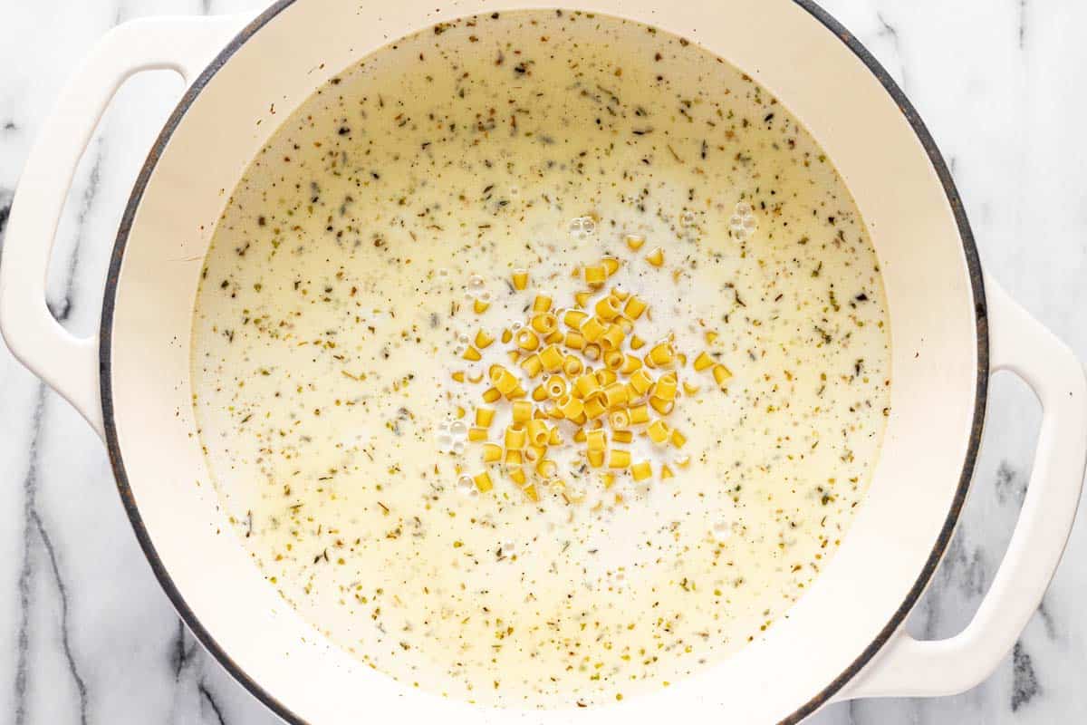 Chicken stock, heavy cream, and pasta in a large pot. 