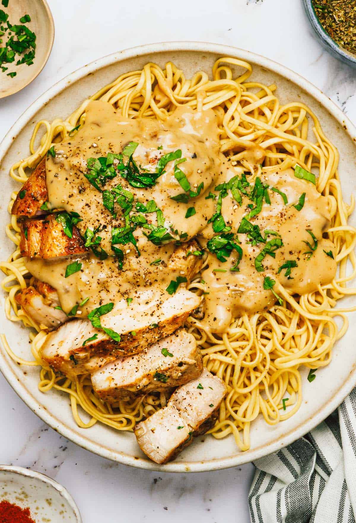 Sliced pork chops and creamy mushroom sauce on a bed of noodles. 