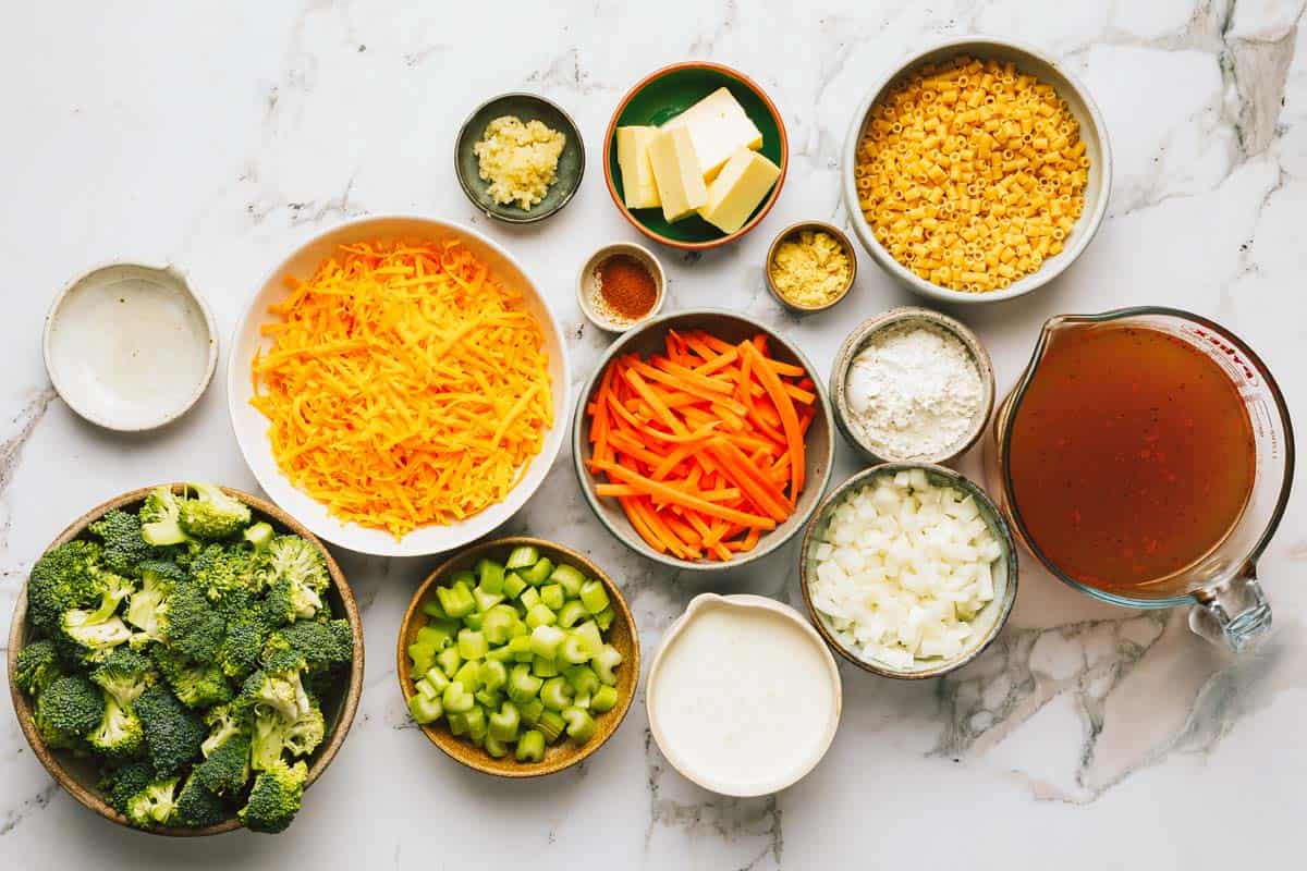 Bowls of ingredients to make broccoli cheese noodle soup. 