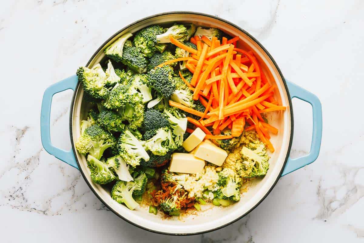 Large pot filled with veggies to make broccoli cheese noodle soup. 