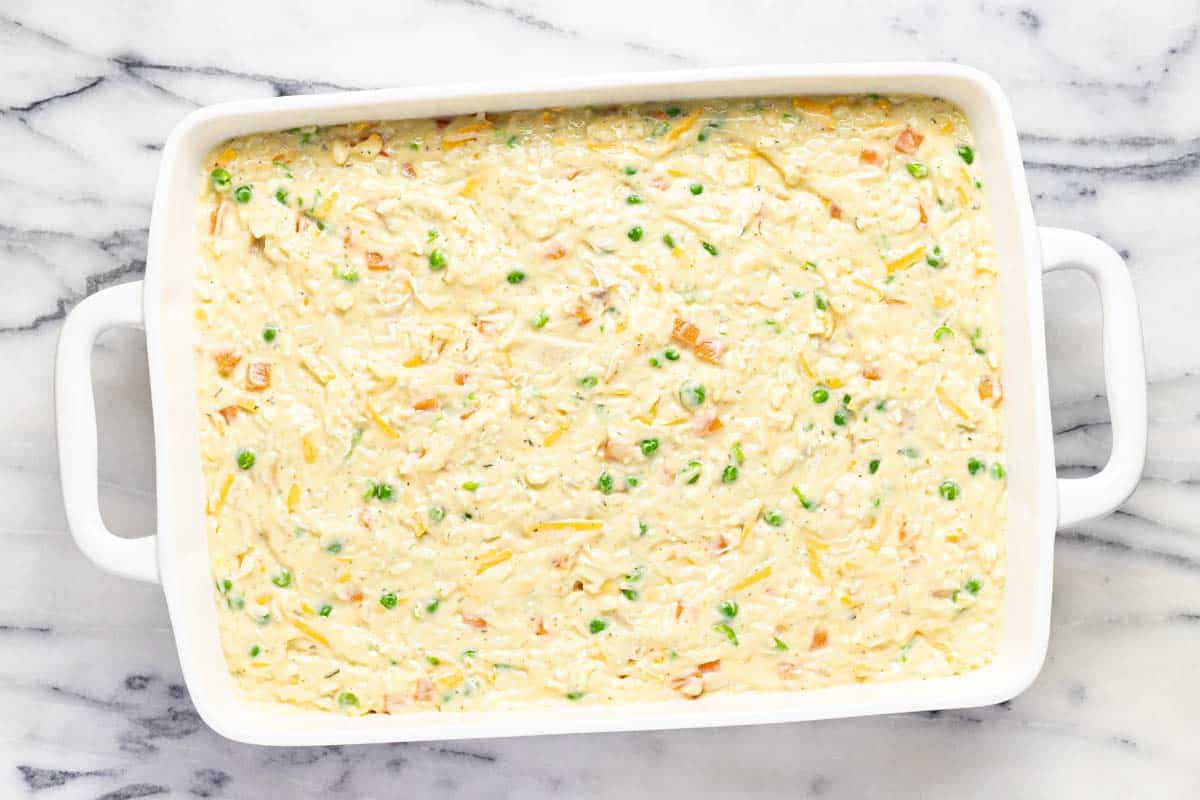 Ingredients for chicken casserole in a large baking dish. 