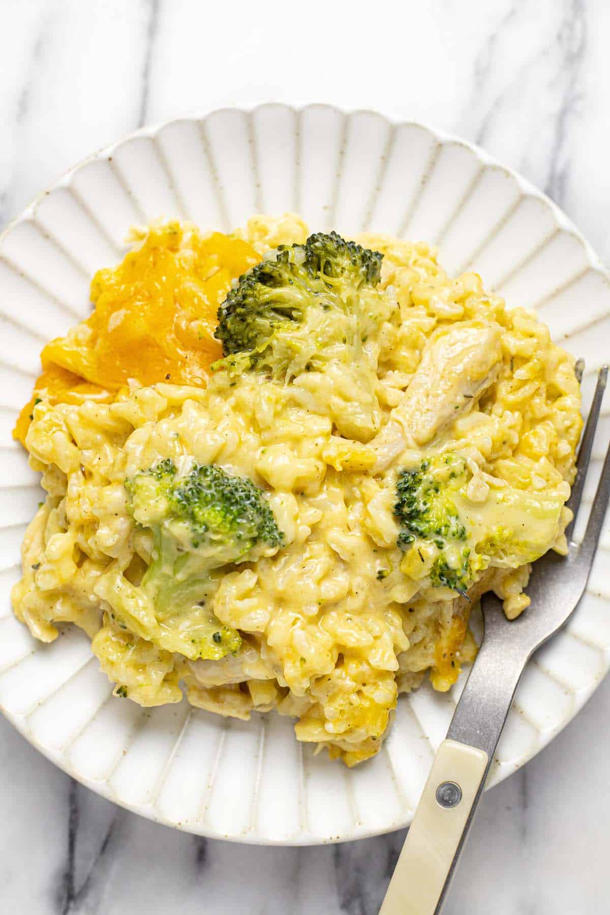 Plate with a helping of cheesy chicken broccoli rice casserole on it. 