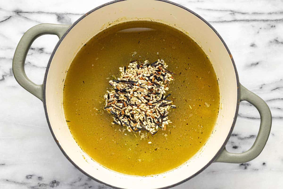 Chicken broth and wild rice blend in a large pot. 