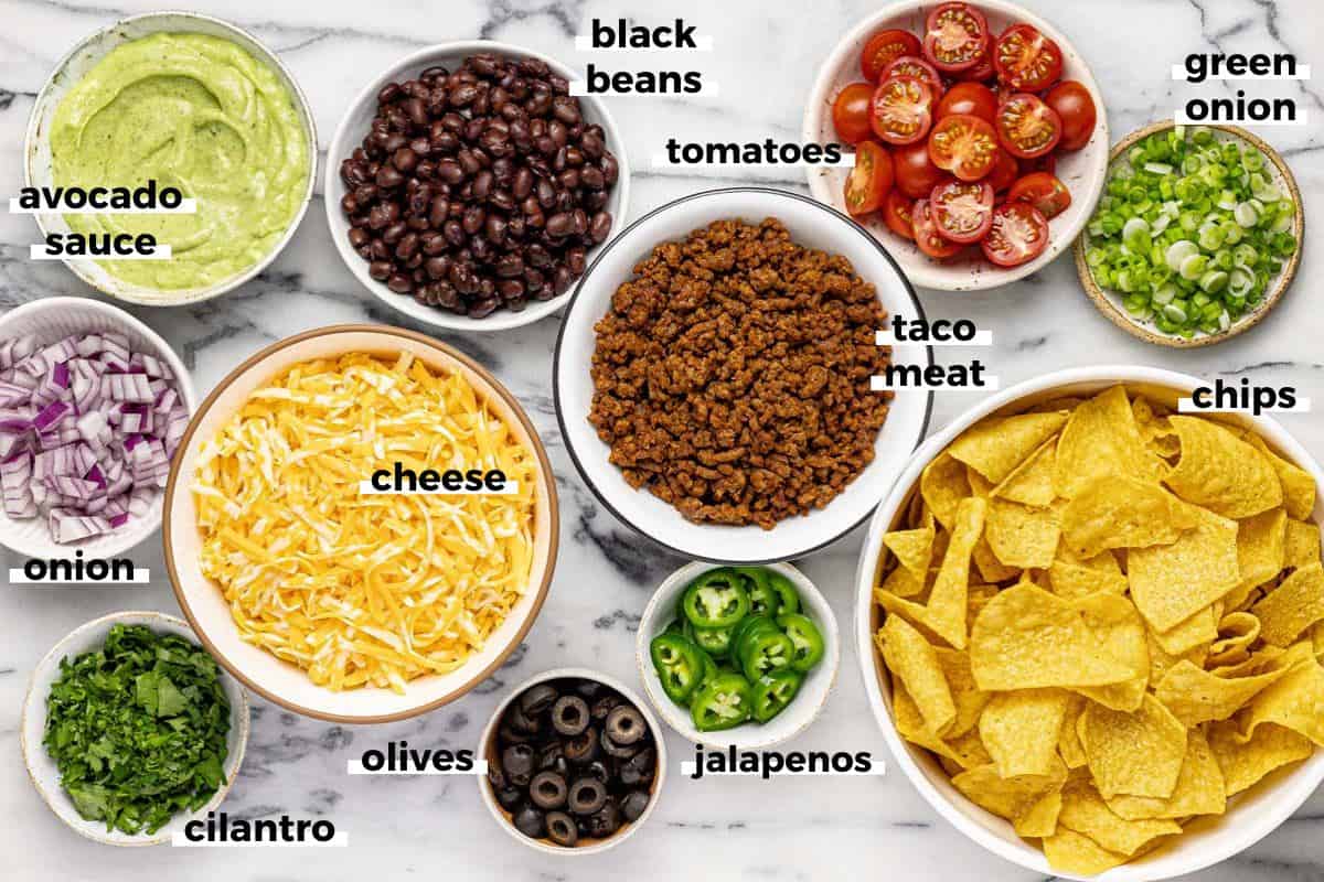 Bowls of ingredients to make loaded nachos recipe. 