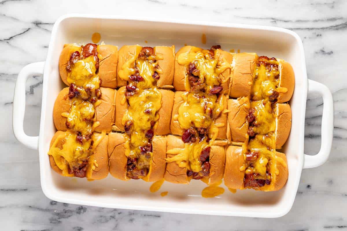 Freshly baked mini chili cheese dogs in a large baking dish. 