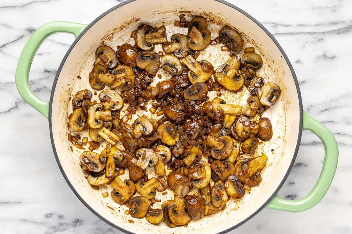 Onions and mushrooms sauteed in a pan. 