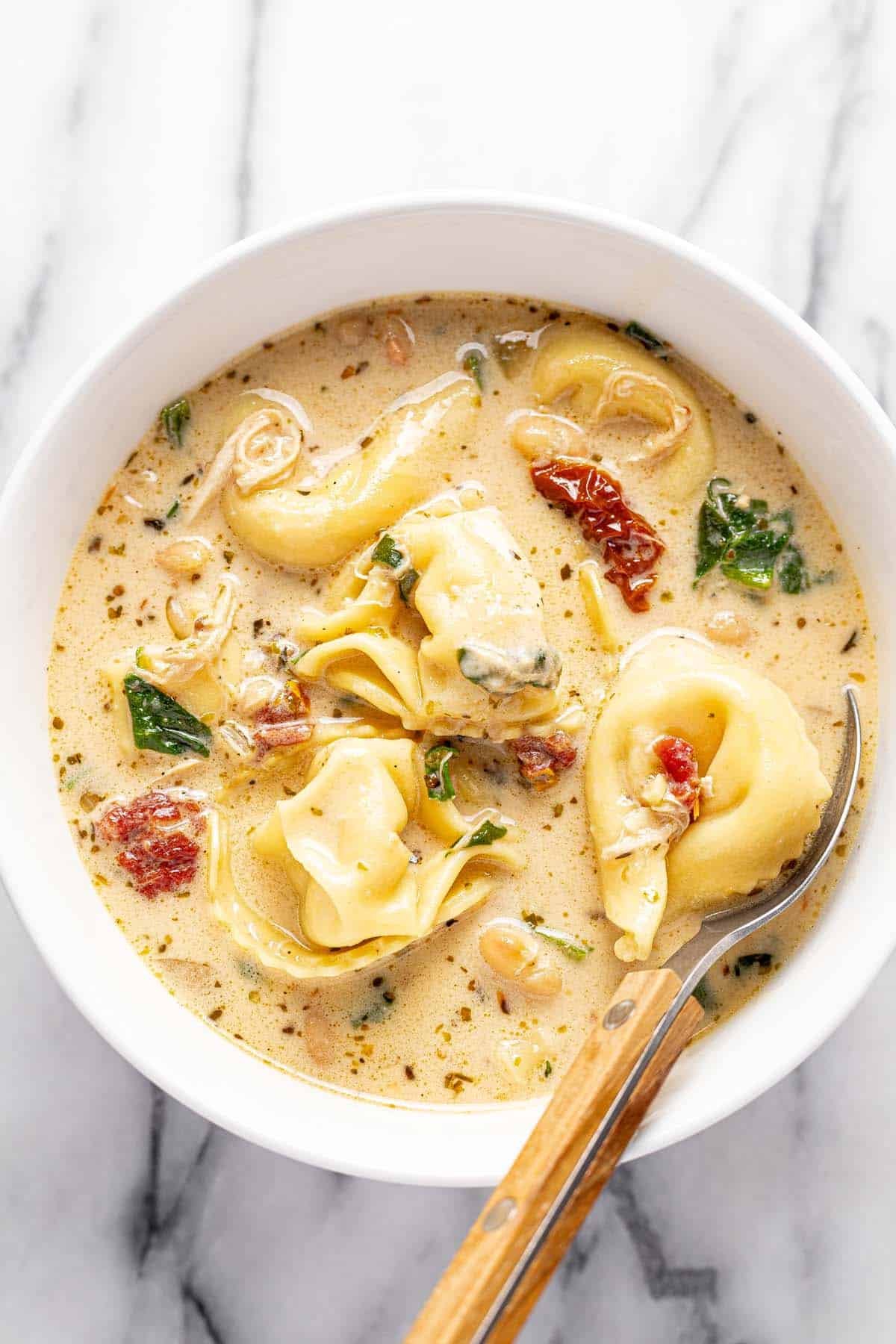 Bowl of creamy Tuscan chicken tortellini soup.