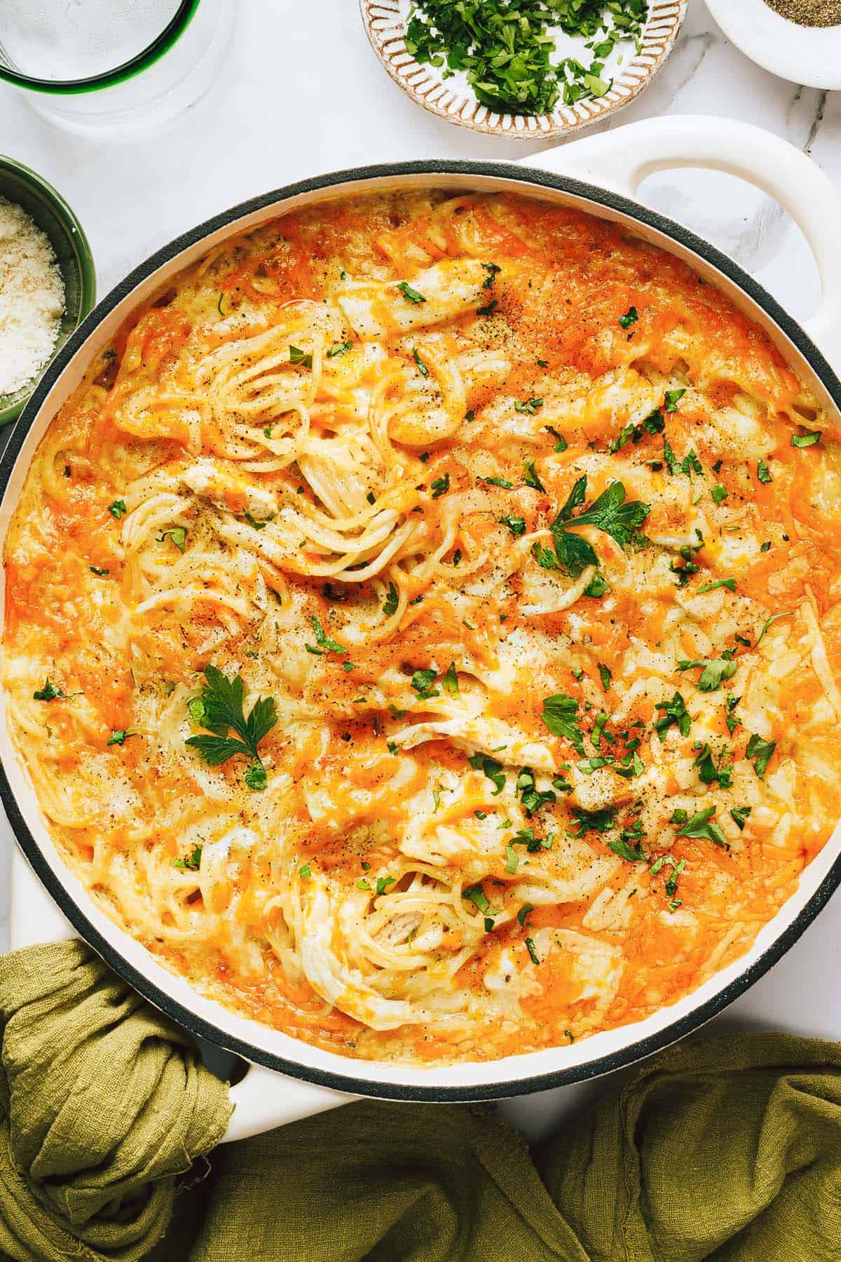 Baked chicken tetrazzini in a large pan topped with chopped parsley. 