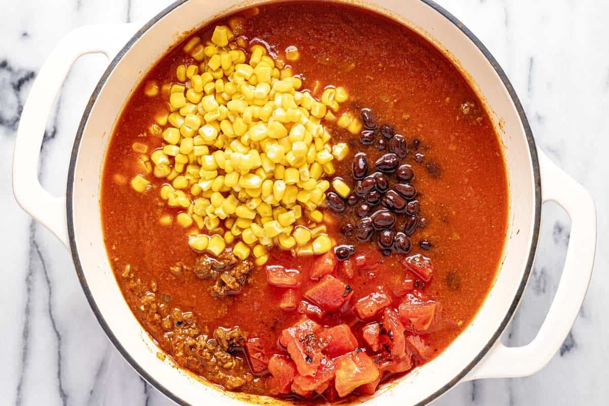 Large pot with V8, corn, black beans, diced tomatoes, and taco meat. 