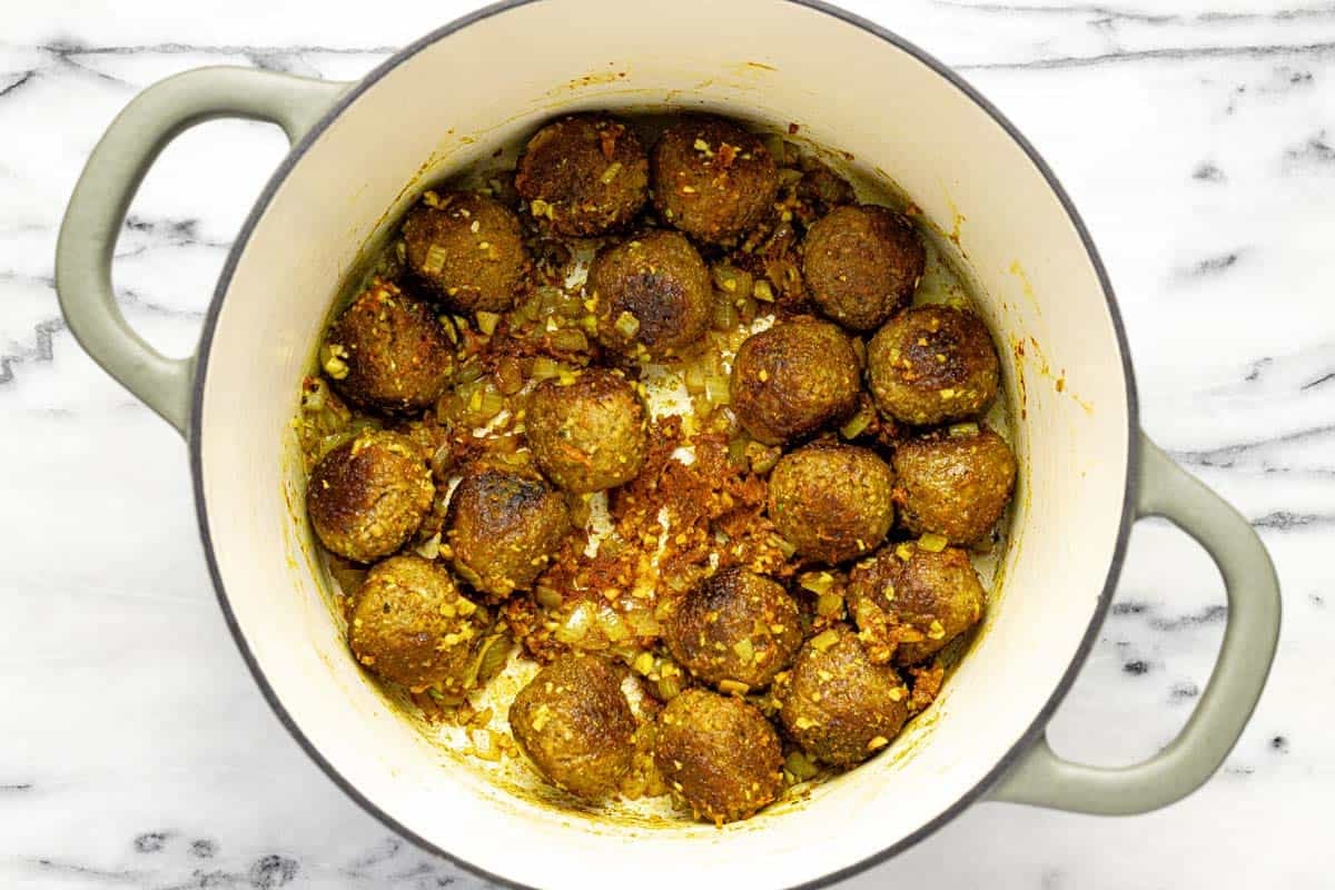 Onion, garlic, curry paste, and meatballs in a large pot. 