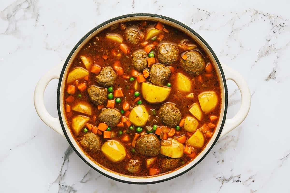 Ingredients for meatball stew in a large pot. 