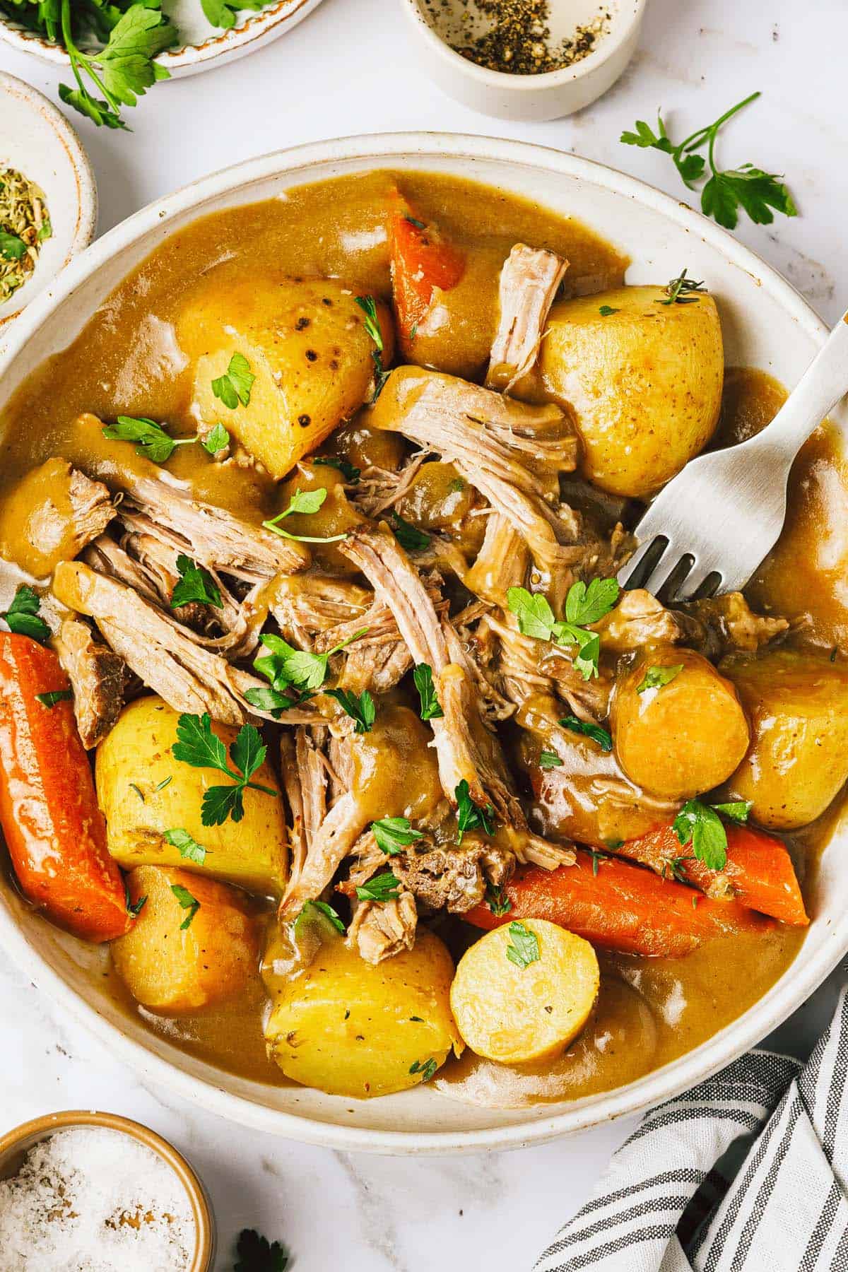 Bowl of shredded pork roast and veggies with gravy on top. 