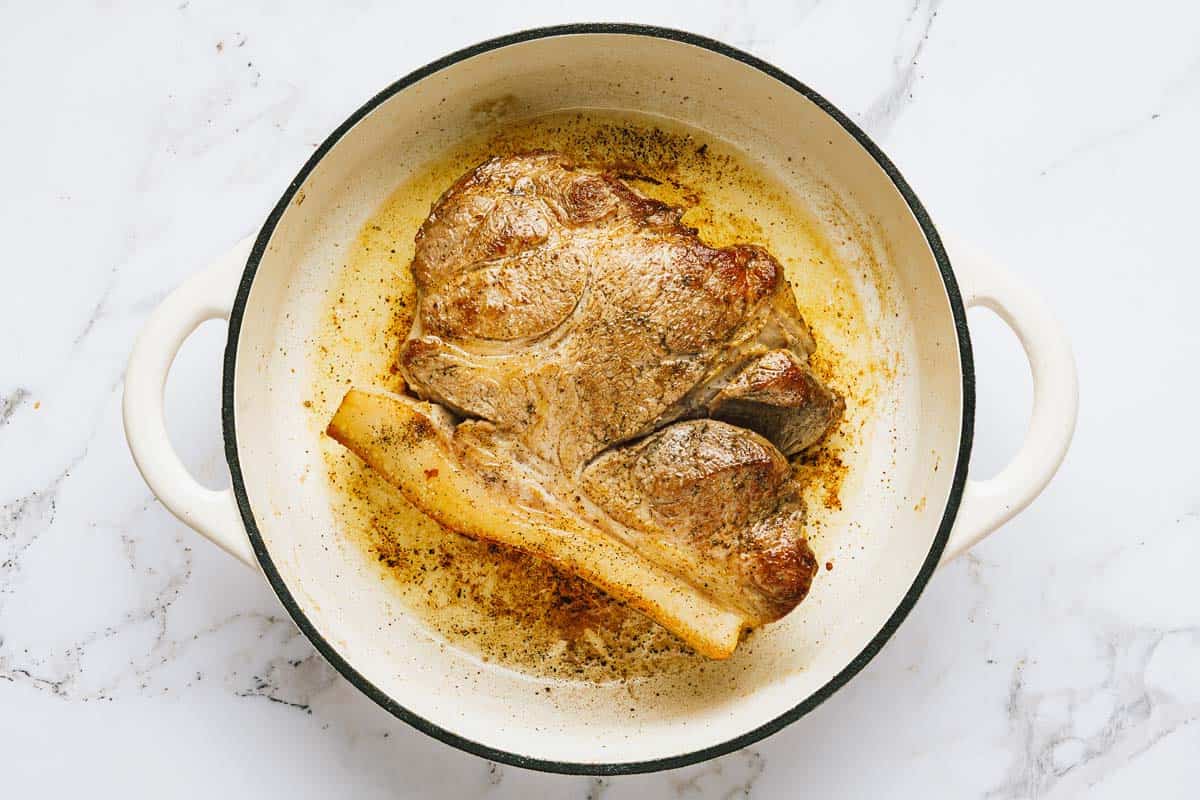 Seared pork roast in a large pan. 