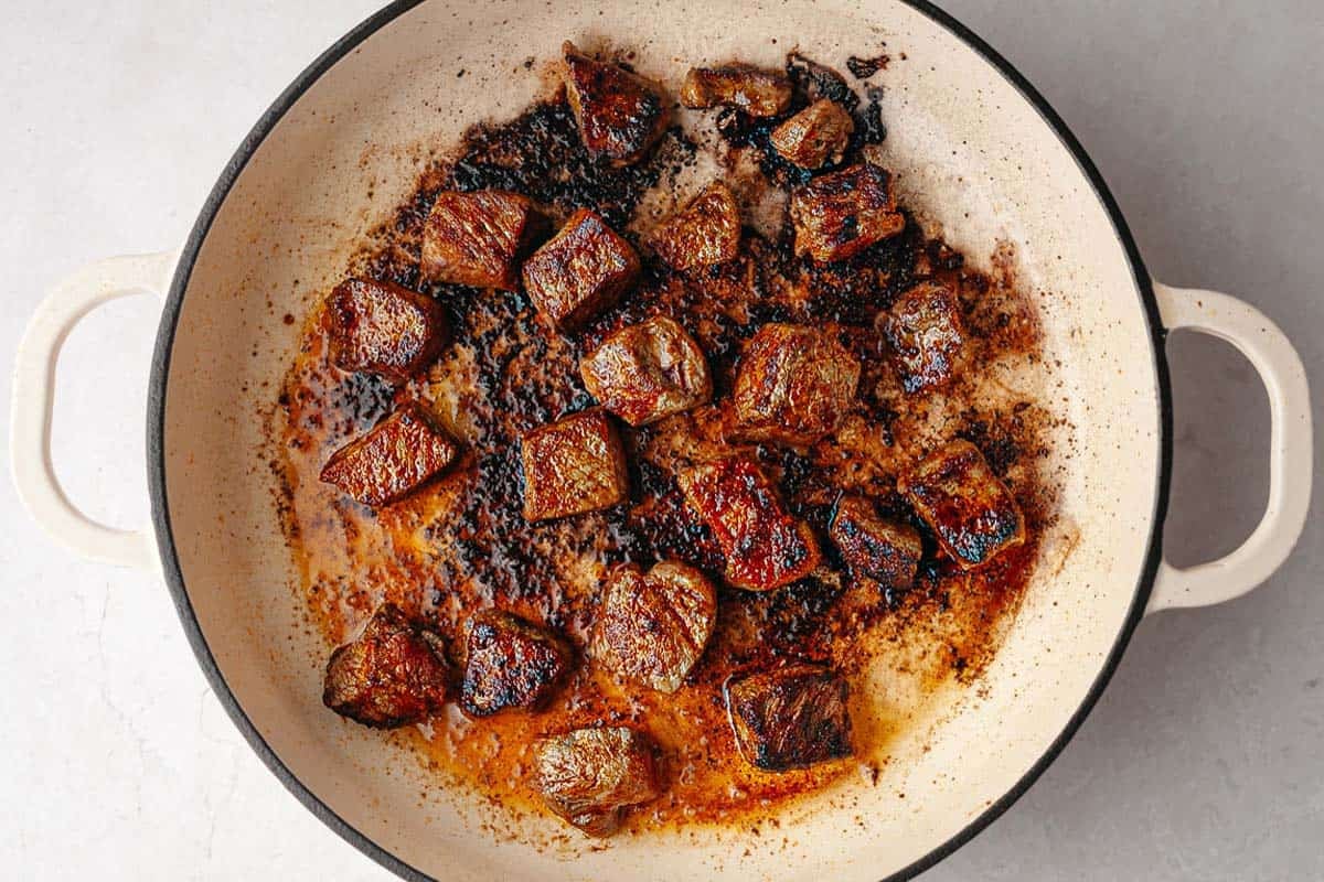 Seared steak bites in a large pan. 