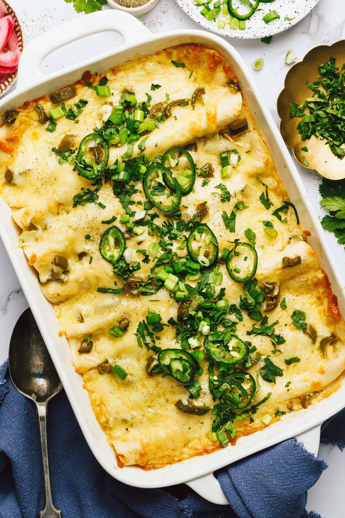 Large baking dish filled with white chicken enchiladas. 