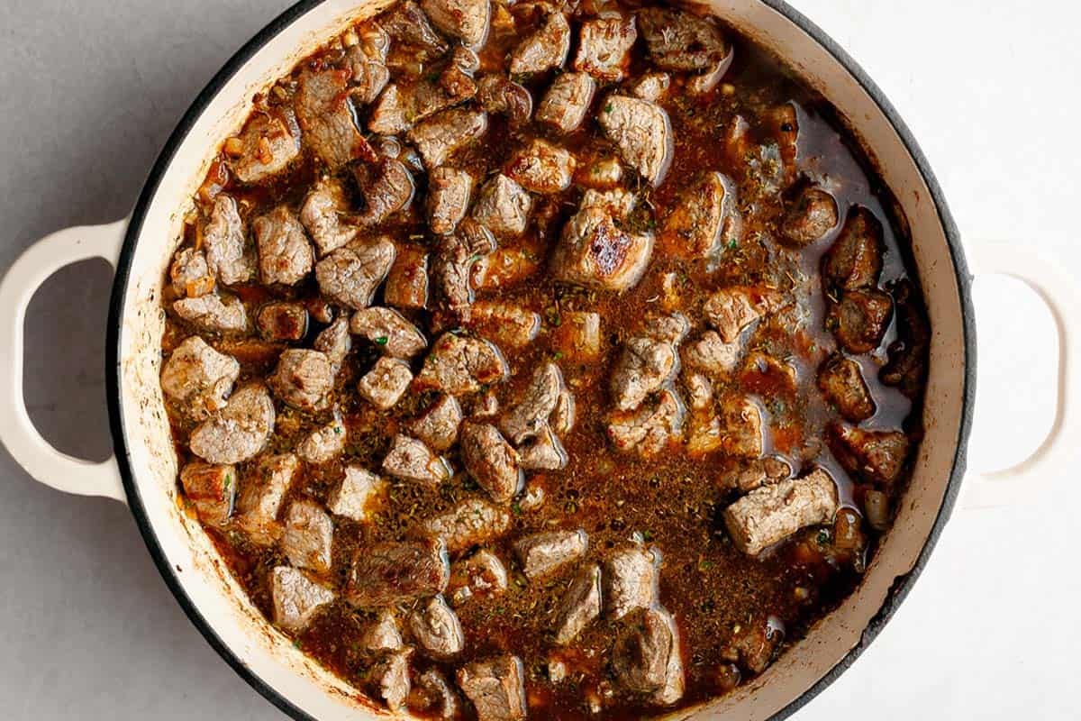 Large pan with ingredients ot make beef tips and gravy. 