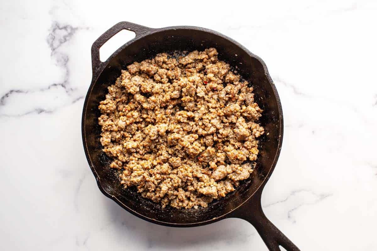 Cooked breakfast sausage in a large cast iron pan. 