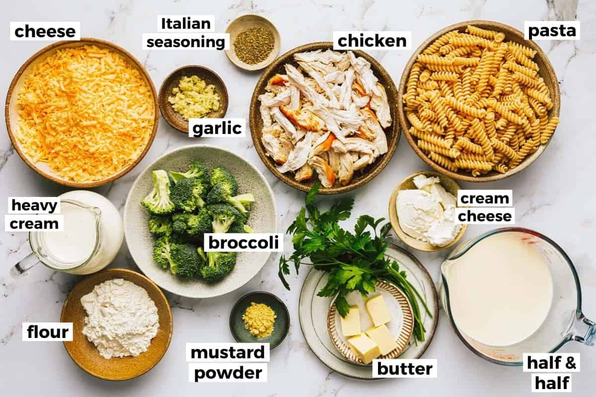 Bowls of ingredients to make cheesy broccoli chicken pasta. 