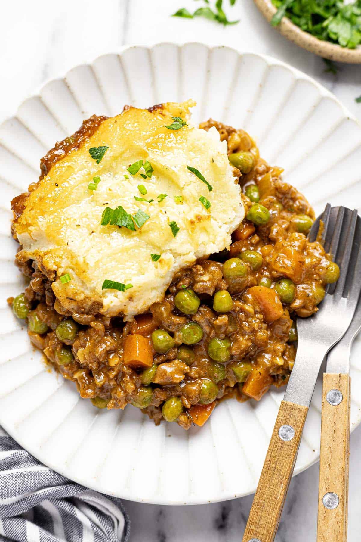 Plate of cottage pie with a fork and spoon. 