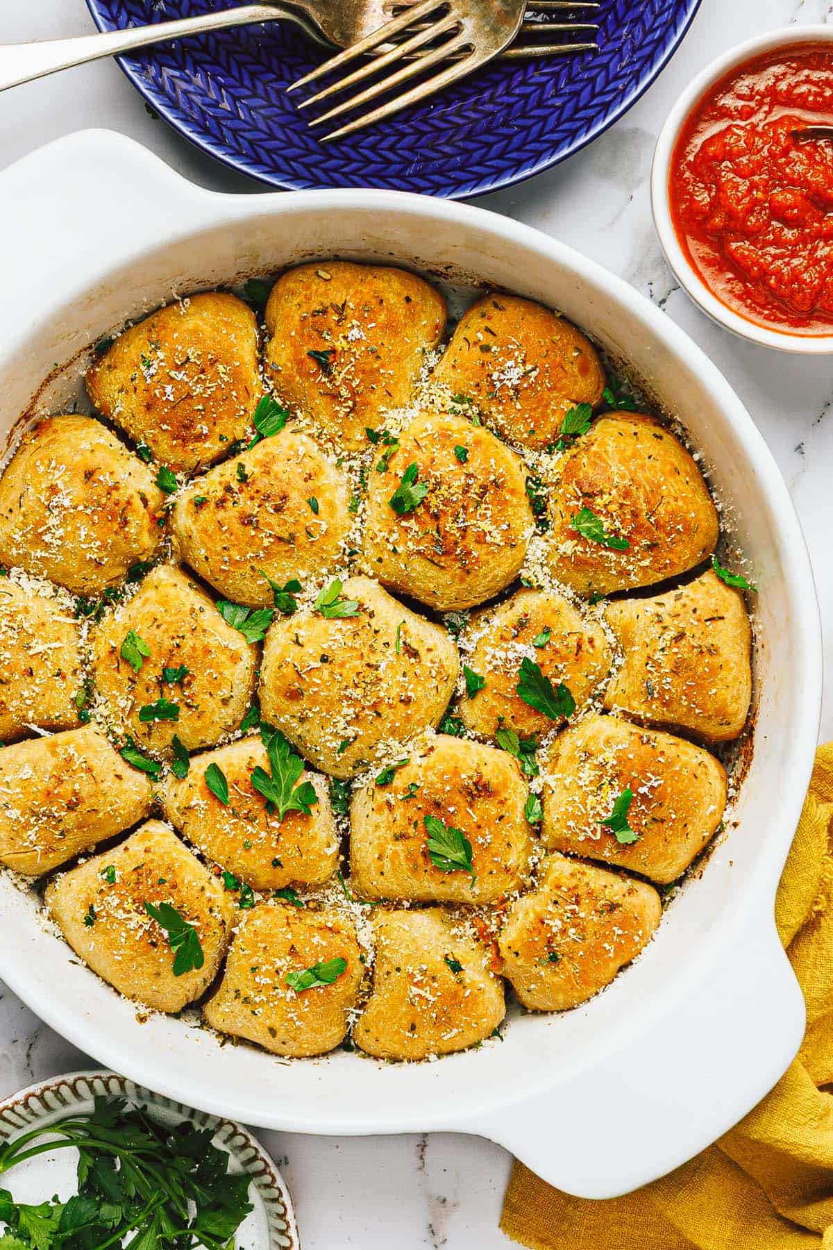 Large pan of pizza bites garnished with Parmesan and parsley. 