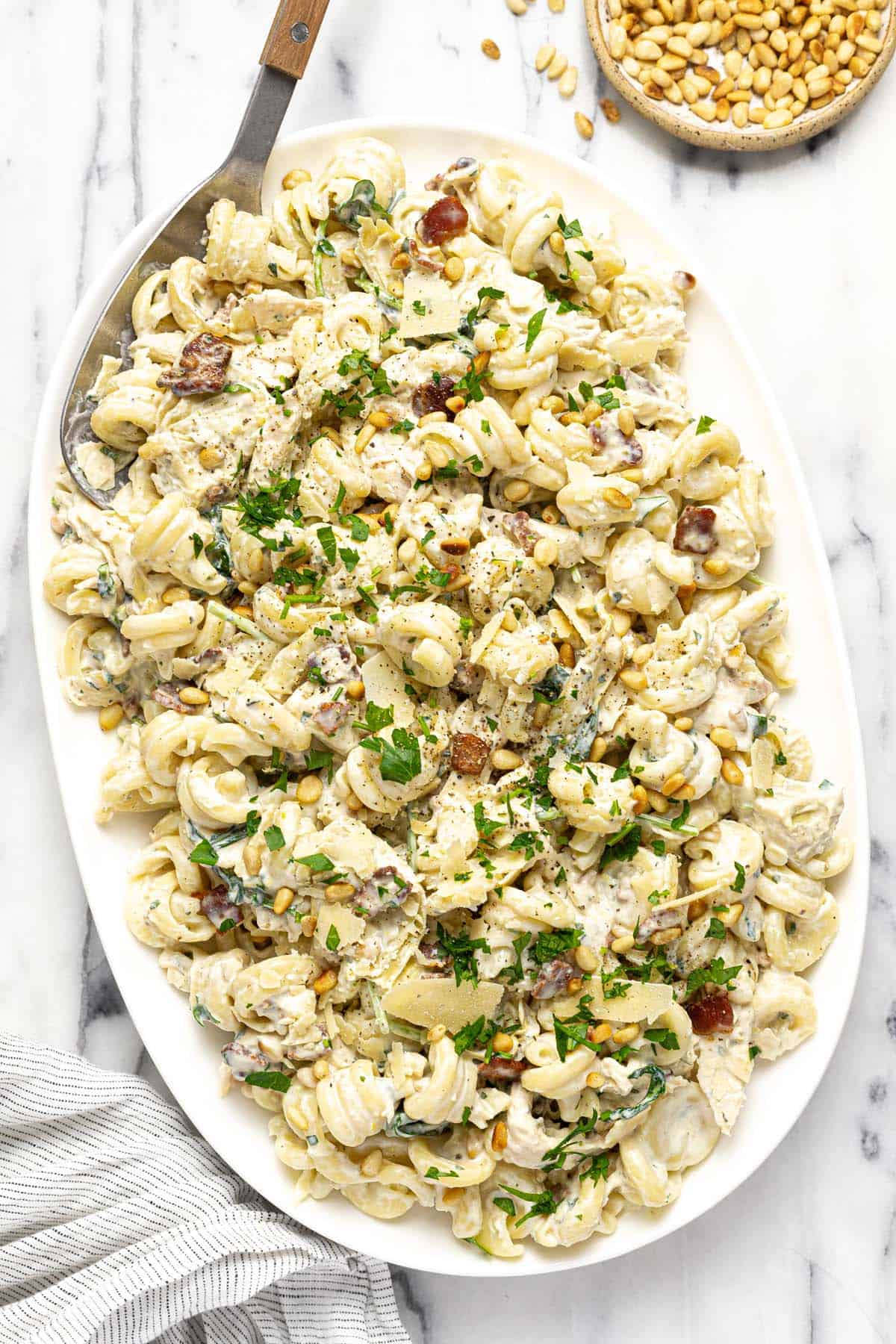 Large serving platter with creamy chicken bacon pasta salad. 