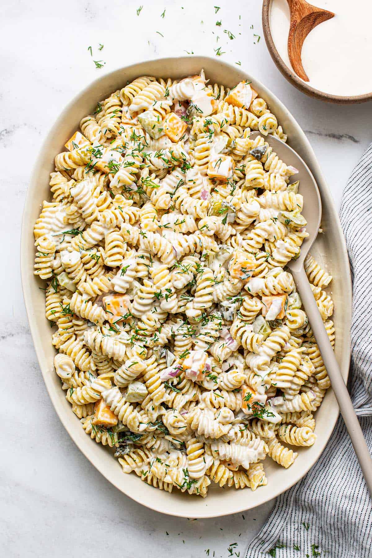 Serving platter filled with dill pickle pasta salad. 