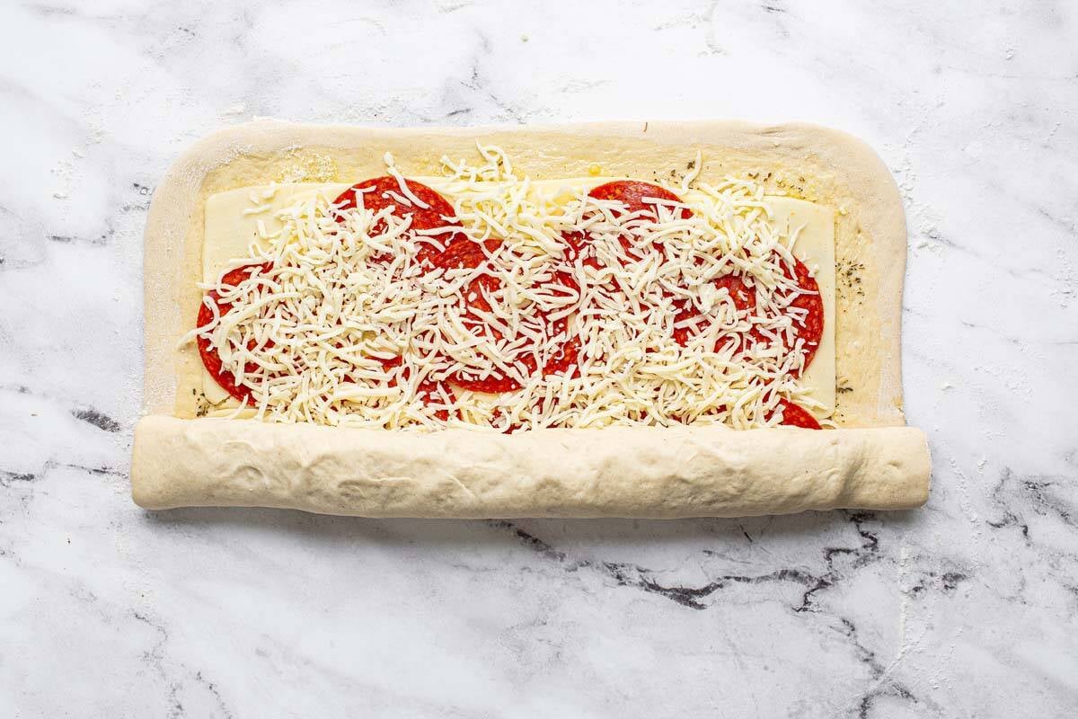 A stromboli being rolled up. 