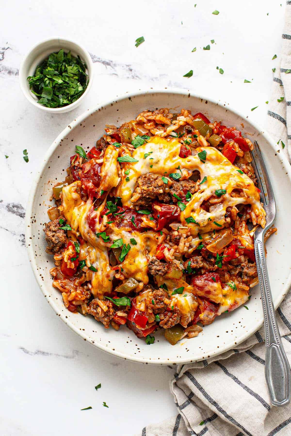 Bowl of stuffed pepper casserole garnished with fresh parsley.