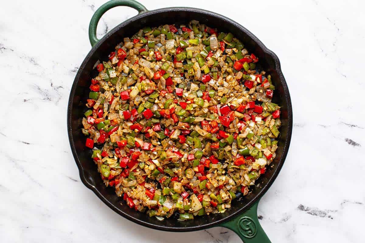 Sauteed veggies and seasonings in a large pan. 
