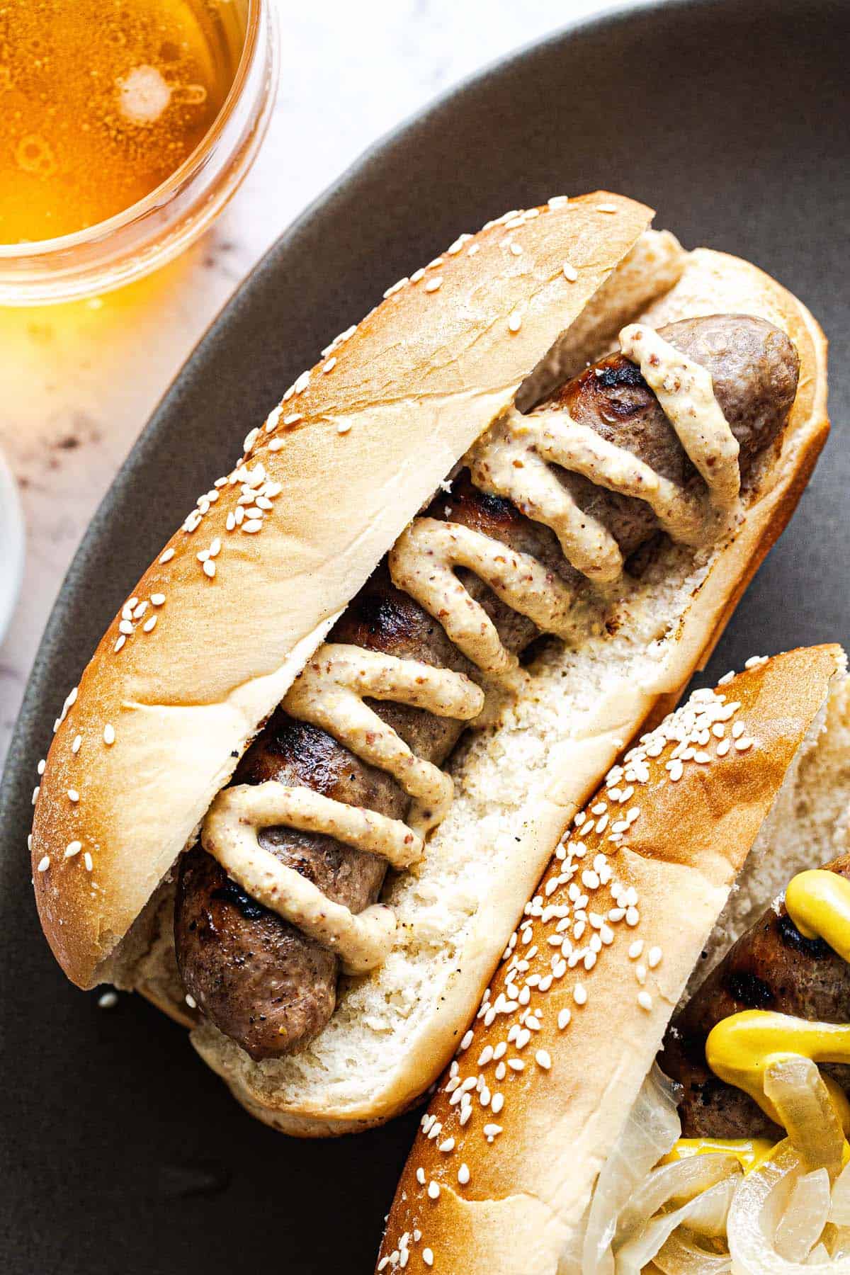 Close up shot of a brat zigzagged with stone ground mustard. 