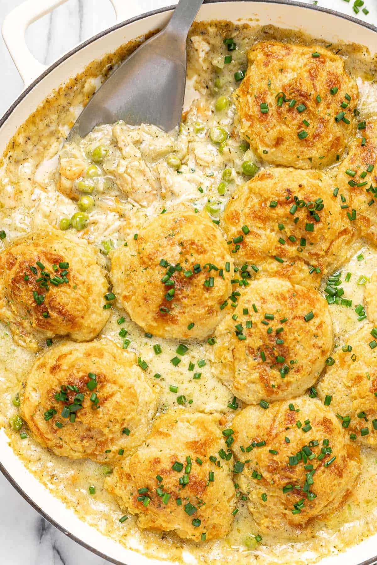 Close up shot of homemade chicken cobbler garnished with chives. 