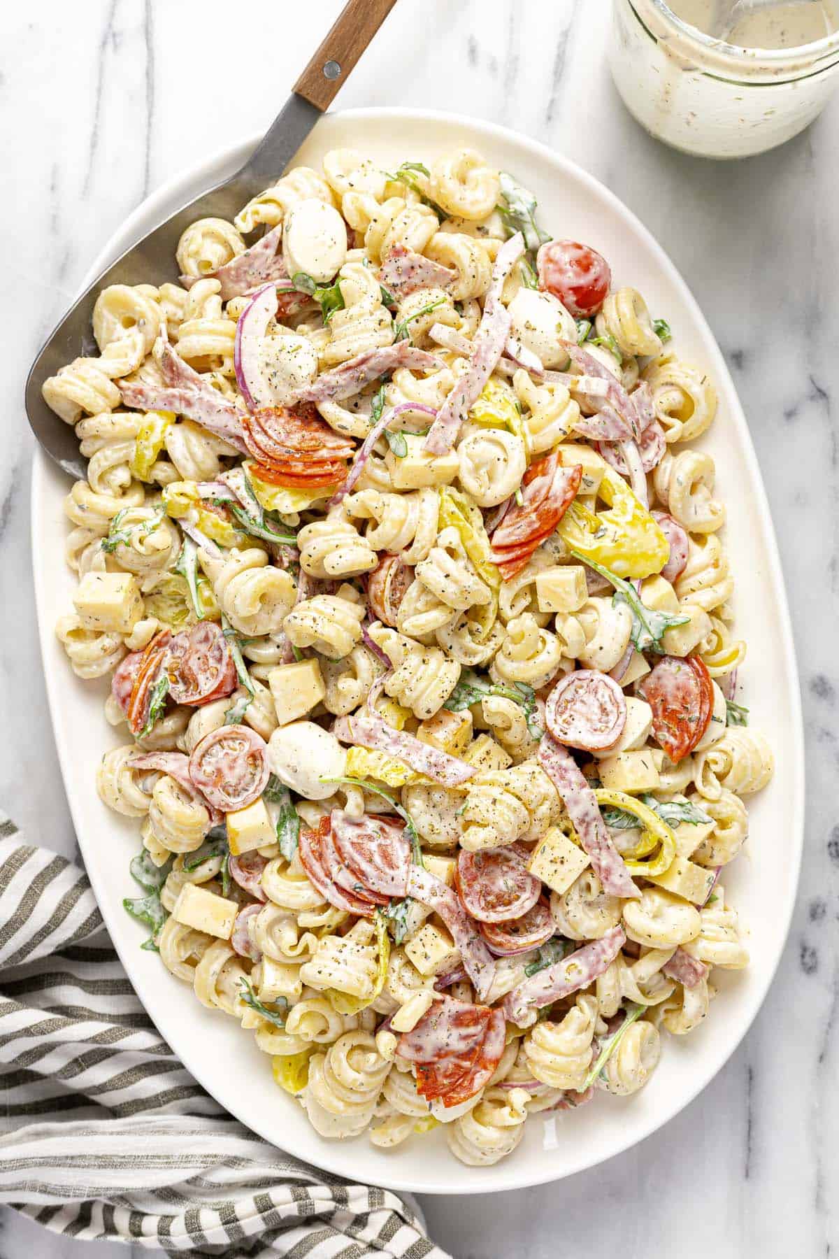 Large serving platter with Italian grinder pasta salad.