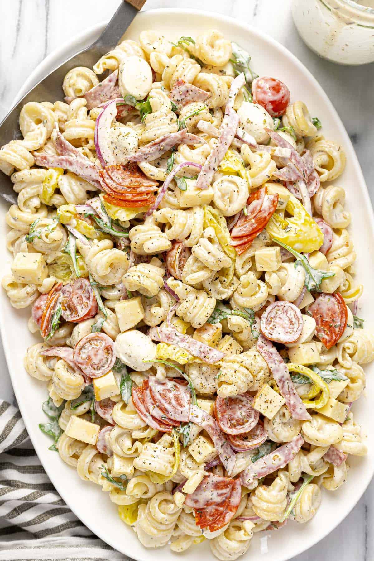 Close up shot of a platter filled with Italian grinder pasta salad. 