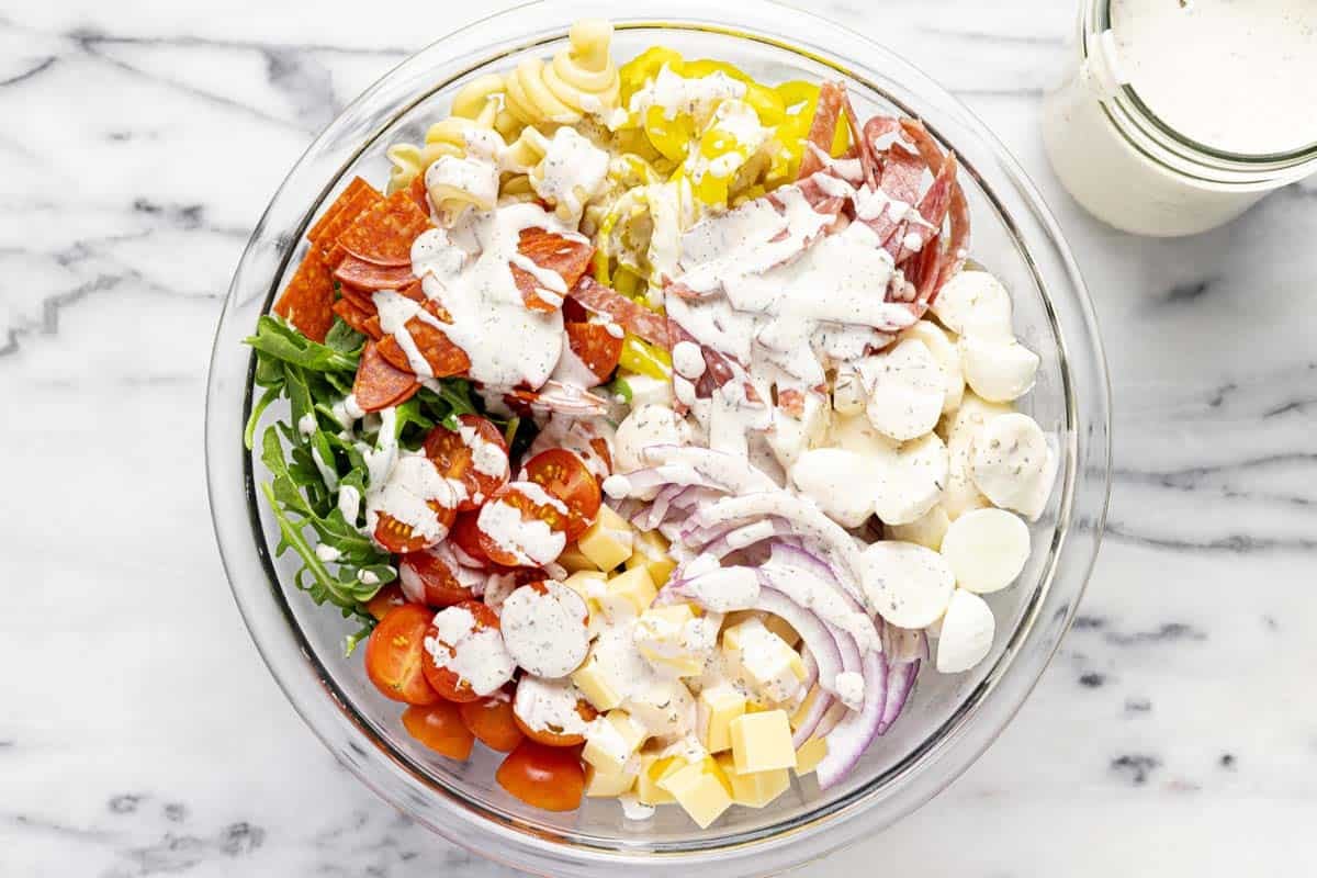 Bowl of pasta salad drizzled with dressing. 