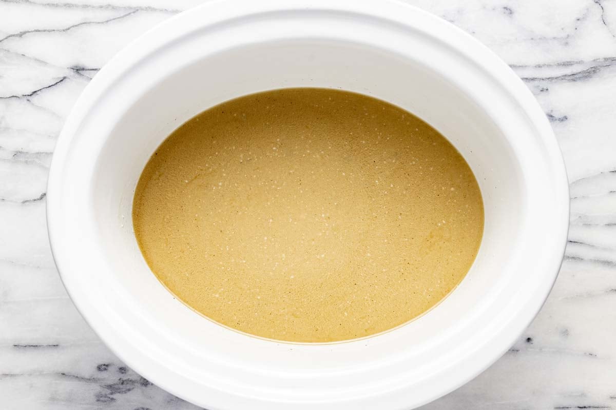 Creamy gravy for beef and noodles in a large slow cooker. 