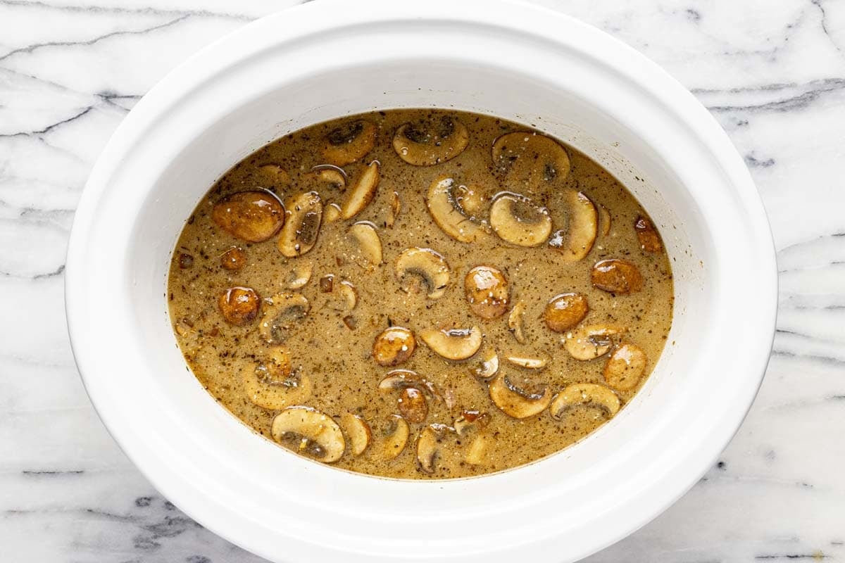 Large crockpot with creamy beef and mushroom sauce. 