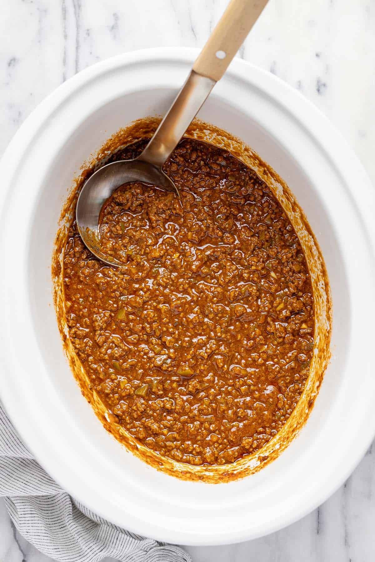 Slow cooker filled with simmered sloppy joe mixture. 