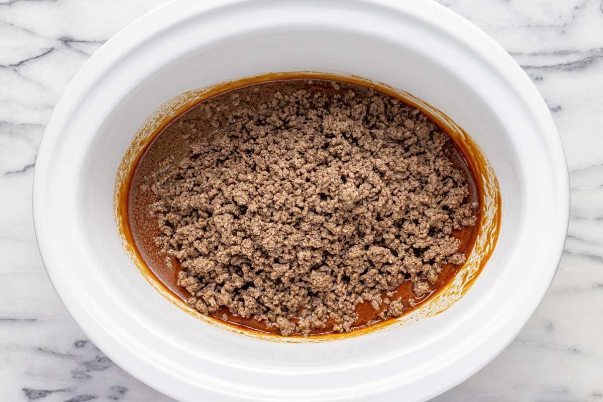 Sloppy joe sauce and ground beef in a large slow cooker. 