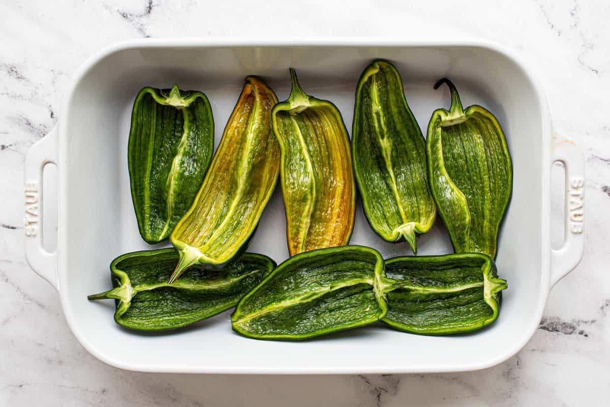 Baking dish with halved poblano peppers. 
