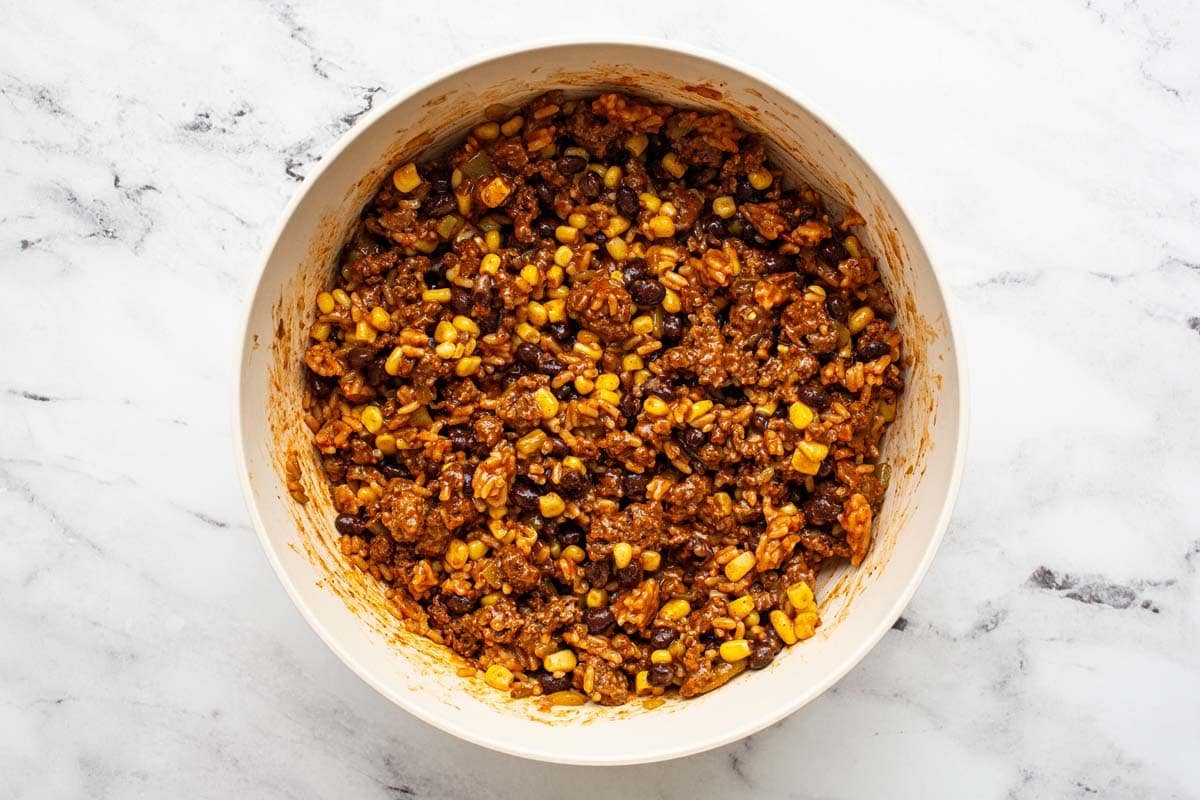 Large bowl filled with stuffed pepper ground beef mixture. 
