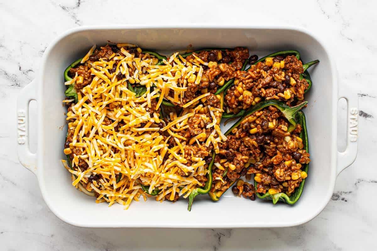Stuffed peppers with shredded cheese on top. 
