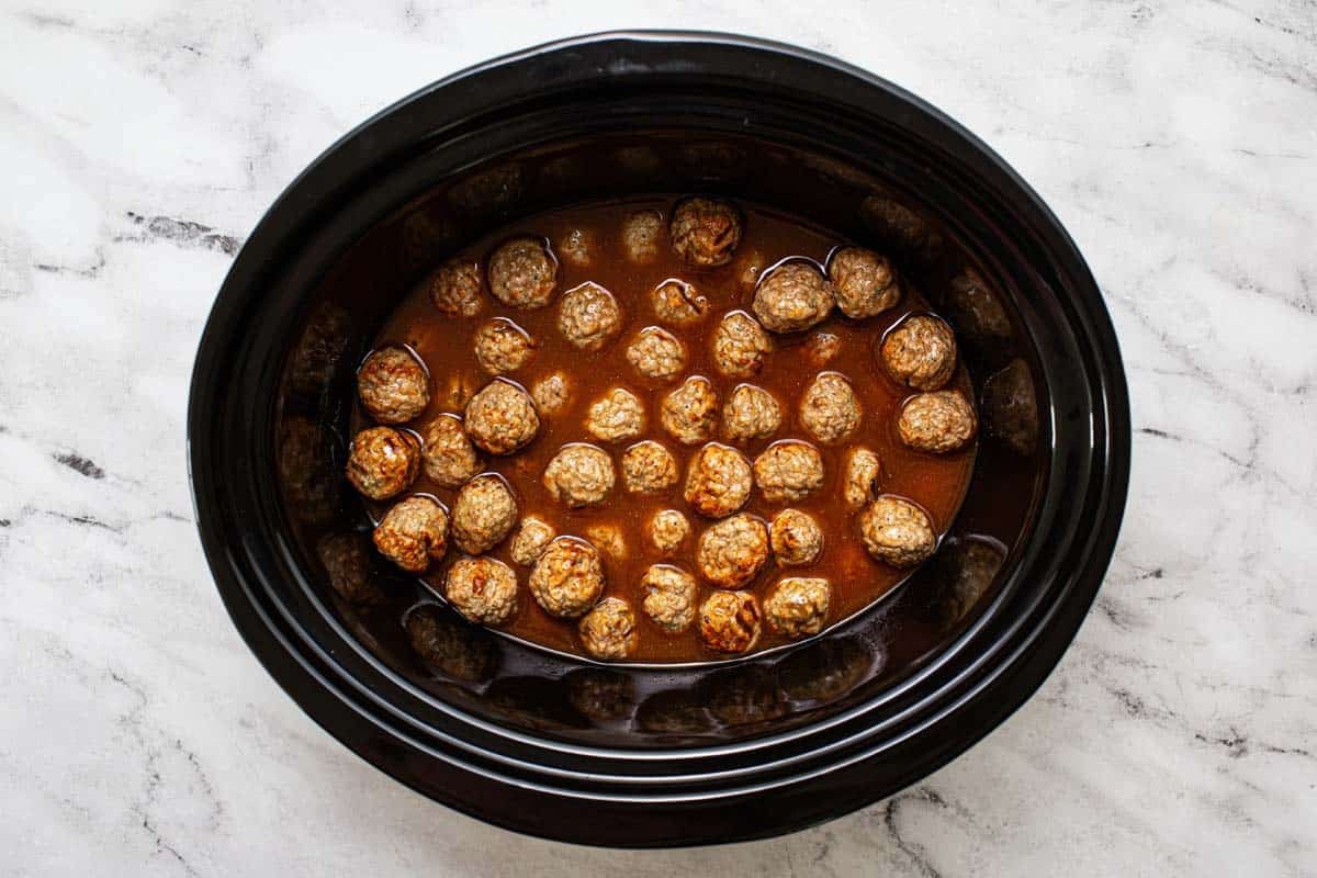 Meatballs and sweet and sour sauce in a large corckpot. 
